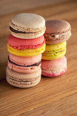 stack of macaron cookies on wooden table and dark background