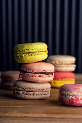stack of macaron cookies on wooden table and dark background