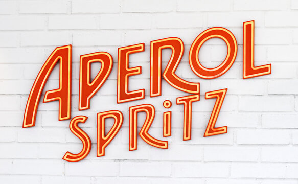 Kiel, Germany, 29 June 2023. Aperol spritz logo on a white brick wall of bar