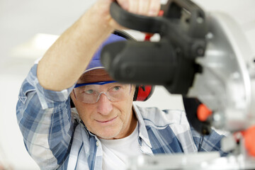 construction worker using slider compound mitre saw