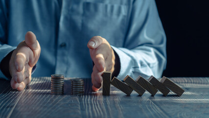 Economic collapse concept, hands stop domino crisis effect, financial and banking problems,...