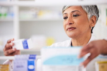 Pharmacist, shelf and a woman with a medicine box in a pharmacy for inventory or prescription. Mature female employee in healthcare, pharmaceutical and medical industry reading product information