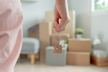 Moving house, relocation. Woman hold key house keychain in new apartment. move in new home. Buy or rent real estate. flat tenancy, leasehold property, new landlord, dwelling, loan, mortgage..