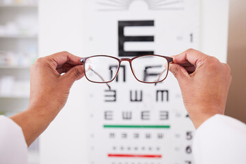 Glasses in hands, optometry and vision, eye care and health with eyesight test and chart,...