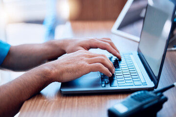 Laptop, radio and hands of security typing or writing an investigation project at a law enforcement office. Police, keyboard and person or officer working on internet crime and criminal email online