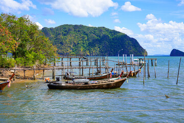 Naklejka na ściany i meble Longtail boats moored next to the Hua Hin Pier of Ko Lanta Noi, where cars board the ferry to Ko Lanta Yai in the Krabi Province of Thailand