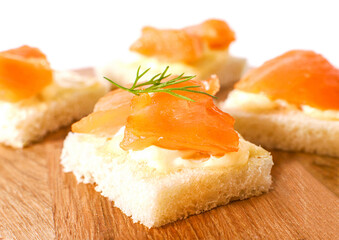 Sandwiches with salmon on wooden background
