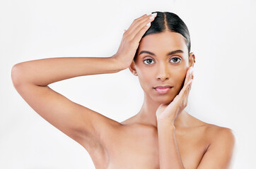Naklejka premium Hands on face, skin care and woman portrait for natural beauty isolated on a white background. Dermatology, makeup glow and cosmetics with Indian female model for facial shine and self love in studio