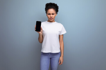 pretty woman with curly hair in white t-shirt with print mockup holding smartphone