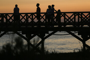 Um momento de conexão em família sobre o Passadiço da Quinta do Lago, enquanto o sol dourado se...