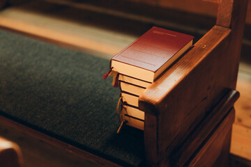 A staple of Bible books on the bench in a church