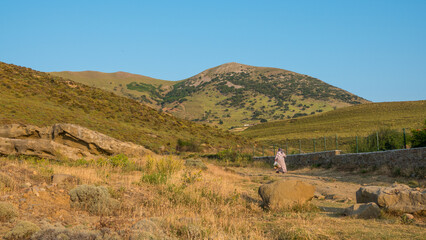 An old unknown peasant woman walking among the valley in Yildizkoy locality of Gokceada.Canakkale,...