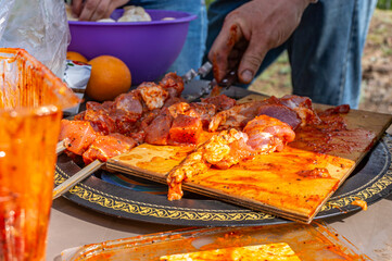 Hands of a man cutting meat with a knife on a barbecue