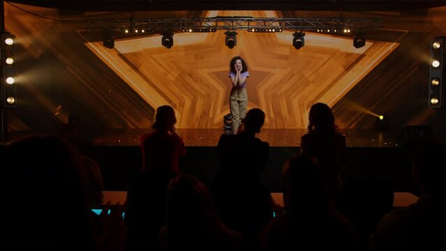 Judges Press The Golden Buzzer To Send A Contestant To A Show Finale, The Lights Changing To Gold, Young Woman Dancer Talent Is Happily Surprised. Television Style Broadcast Talent Show