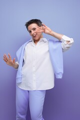 vertical photo of a stylish fashionable young lady with tousled hair in a white shirt in an informal setting