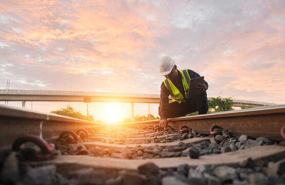 Asian engineer inspects trains Construction workers on the railway Engineer working on railway depot maintenance