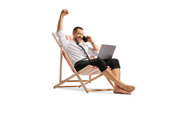Happy bussinesman on a beach chair using a laptop and a smartphone