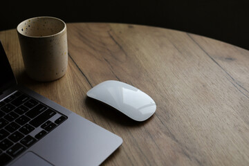 computer white mouse on wooden table laptop and cup. place for text