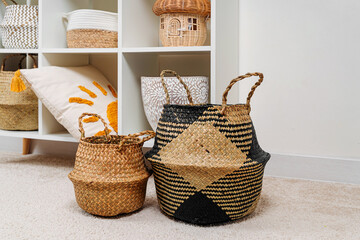 White shelving with  various baskets. Seagrass Belly basket , Cloth, and wicker  baskets for...