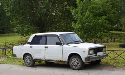 An old white Soviet car in the courtyard of a residential building, Badaeva Street, St. Petersburg, Russia, July 07, 2023