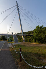Metal suspension bridge for pedestrians with steel cables over the Neckar river near Hassmersheim with reflections