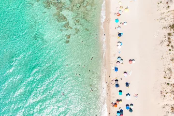 Fototapeten Aerial view of colorful umbrellas on sandy beach, people in blue sea at summer sunny day. Apulia, Salento, Italy. Tropical landscape with turquoise water. Travel and vacation. Top drone view © Andrea Carro