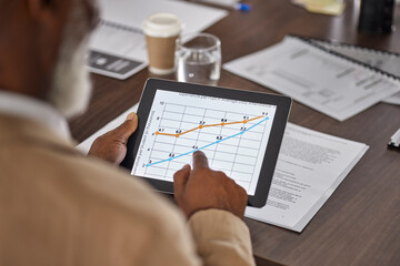 Hand of man in meeting with tablet, charts and graphs, stats for sales report, data and information in office. Business growth, online statistics or performance review, analytics in profit research.