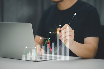 A businessman or accountant using laptop to analyze financial investments and business and marketing growth on a data graph. The concepts of accounting, economics, and commercial analysis.