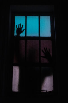 Silueta de hombre detr&aacute;s de una ventana