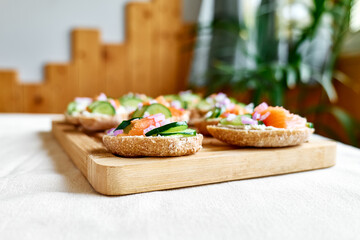 Open sandwiches with smoked salmon, cream cheese and sliced cucumber. Summer bruschetta appetizer ideas. Healthy eating.