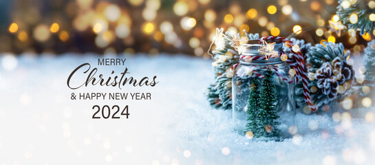 Christmas Card - Merry Christmas and Happy New Year 2024 - Christmas tree in snow and magic bokeh lights - background banner, header, xmas greetings - 621011451
