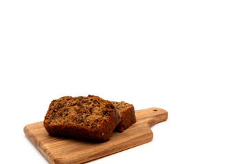 Slices of freshly baked homemade chocolate banana bread on a wooden board. Isolated on white background with copy space.