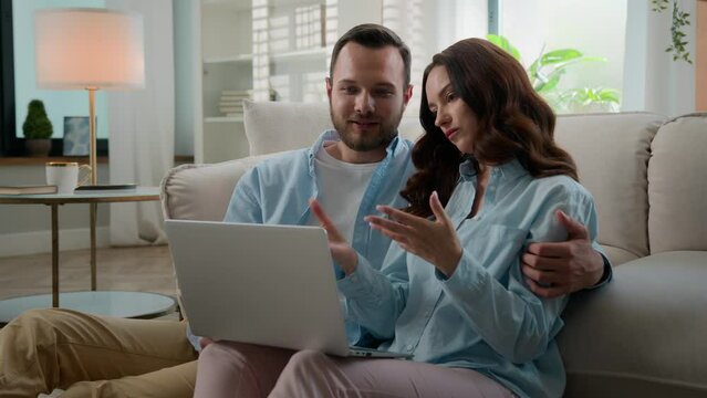 Happy family combined budget Caucasian couple using laptop for ecommerce online shopping together discuss talking hugging at home sofa man and woman looking at computer buying choosing order delivery