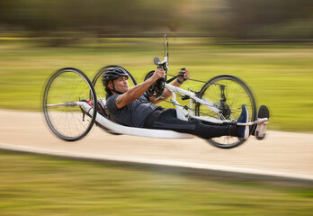 Cycling, fitness and fast with man and handcycle in nature for training, sports and challenge. Exercise, workout and motion blur with person with a disability in park for cardio and health on road