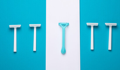 Disposable plastic razors on blue white background, minimalism beauty still lefe. Top view. Creative layout