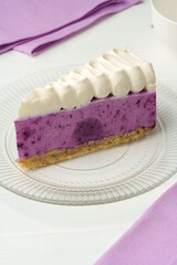 Cut tasty blueberry cake on white table