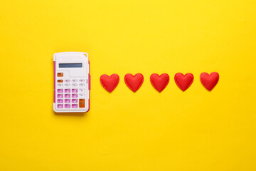 Calculator with red hearts on yellow background
