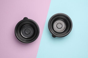 Disposable black plastic empty food containers on pastel background. Top view