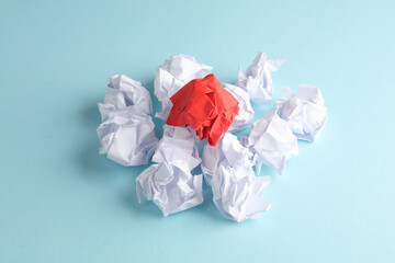 Crumpled white and red balls of paper on a blue background. Leadership, uniqueness, business concept