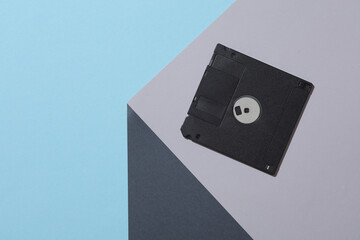 Floppy disk on the corner of gray cube. Optical geometric illusion. Creative layout. Minimalism. Retro 80s