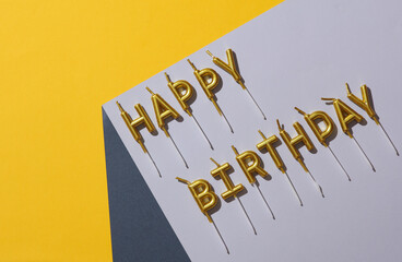 Happy birthday candles on the corner of gray cube. Optical geometric illusion. Creative party...