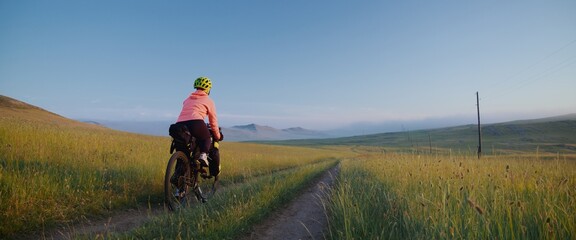 The cyclist traveling around the world. The woman is ride on bike with bikepacking bags. Live...