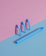 Plastic blue pen with caps on a blue-pink background. Business, education concept. Creative layout, minimalism