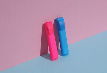 Plastic blue and pink markers on a blue-pink background with shadow. Business, education concept. Creative layout, minimalism