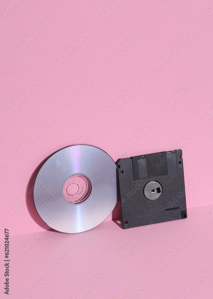 Poster floppy and cd disks on a pink background. retro 80s. outdated technology. creative layout, minimalis