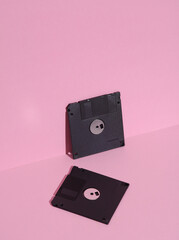 Floppy disks on a pink background. Retro 80s. Outdated technology. Creative layout, minimalism, trendy minimal still life