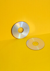 cd disks on yellow background. Retro 80s. Outdated technology. Creative layout, minimalism, trendy minimal still life