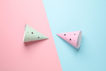 Birthday cone caps on a blue-pink background. Party concept. Top view