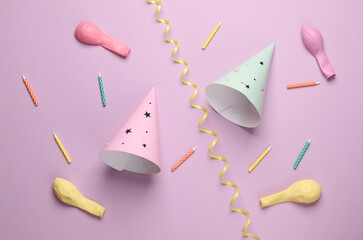 Birthday cone caps candle and balloons on pastel background. Party concept. Top view