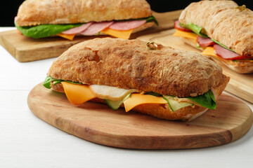 Chiabatta sandwich with ham and cheese on wooden board